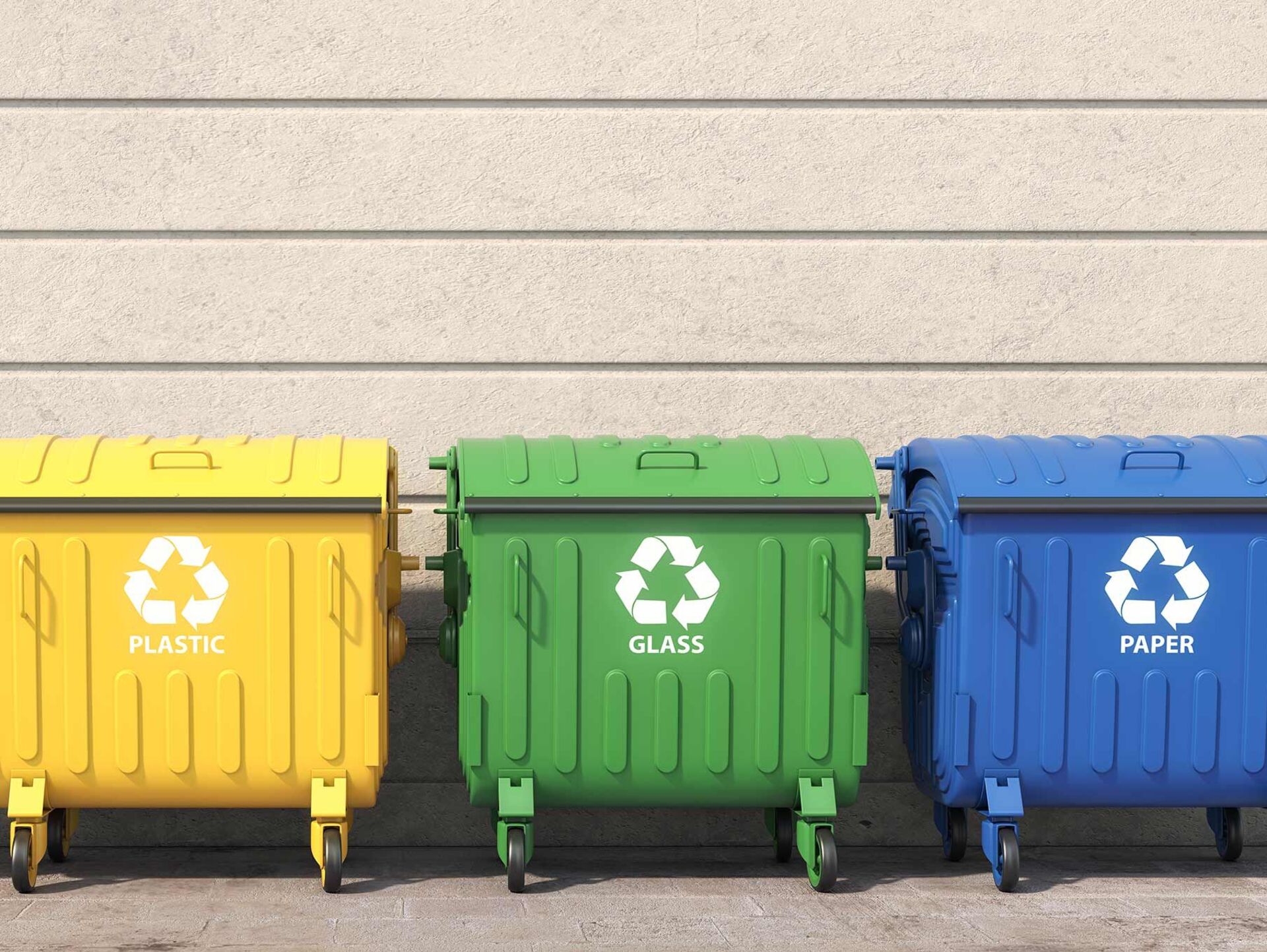 Recyclability Three large recycling containers stand next to each other in front of a wall: a yellow one for plastic, a green one for glass and a blue one for paper