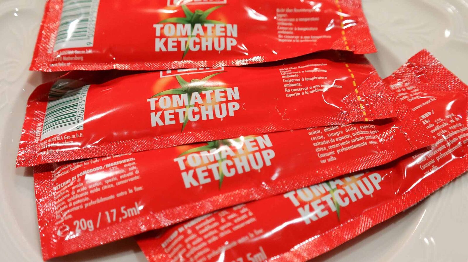 Prohibited: Mini portions of ketchup, mayonnaise, mustard etc. in disposable plastic packaging There are four individual portions of ketchup in plastic packaging on a white plate