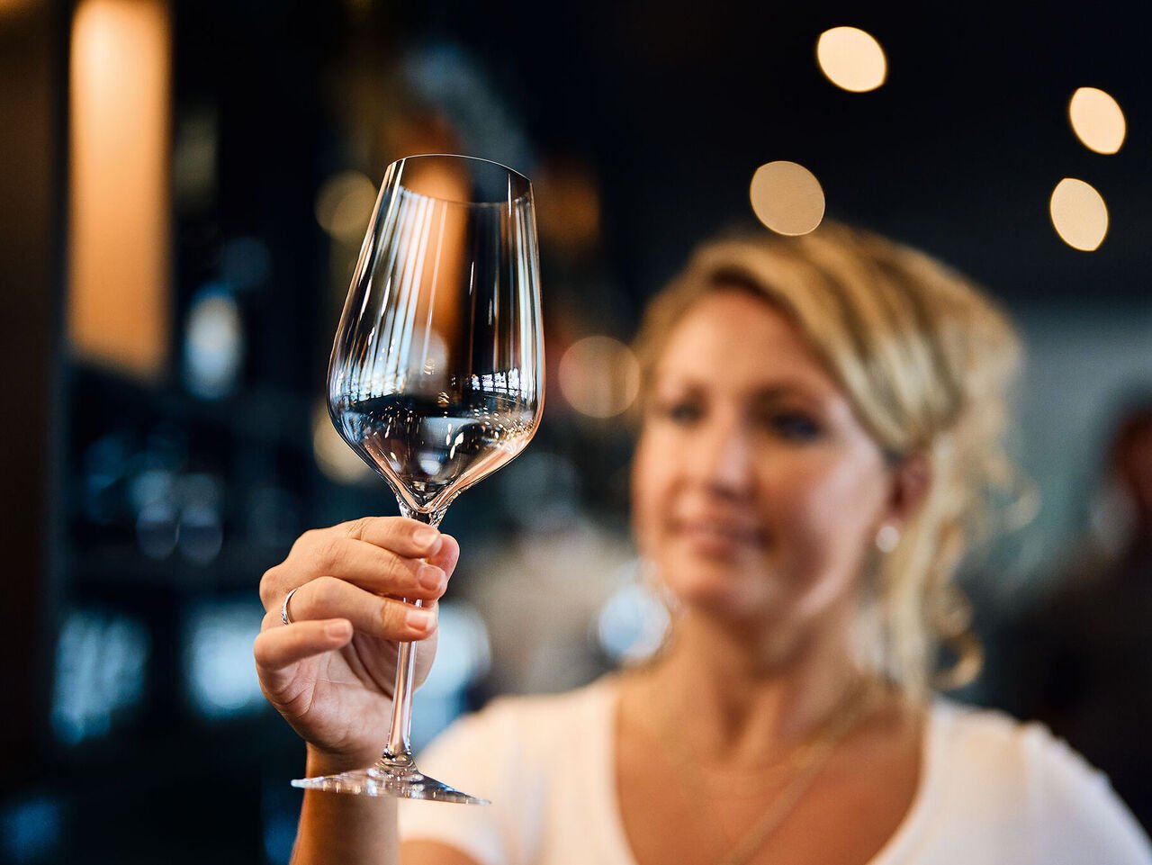 Lavage des verres : les restaurateurs adorent les verres brillants !  Une serveuse du restaurant vérifie si le verre à vin lavé est impeccablement propre