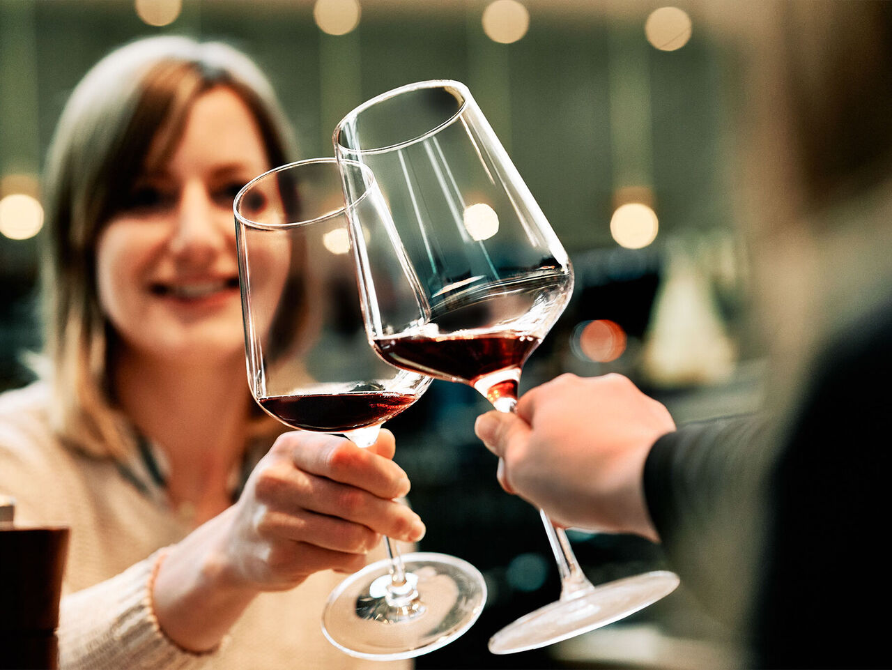 Gläserspülen: Gäste lieben brillante Gläser! Gäste sitzen am Tisch im Restaurant und stoßen mit perfekt gespülten Weingläsern an