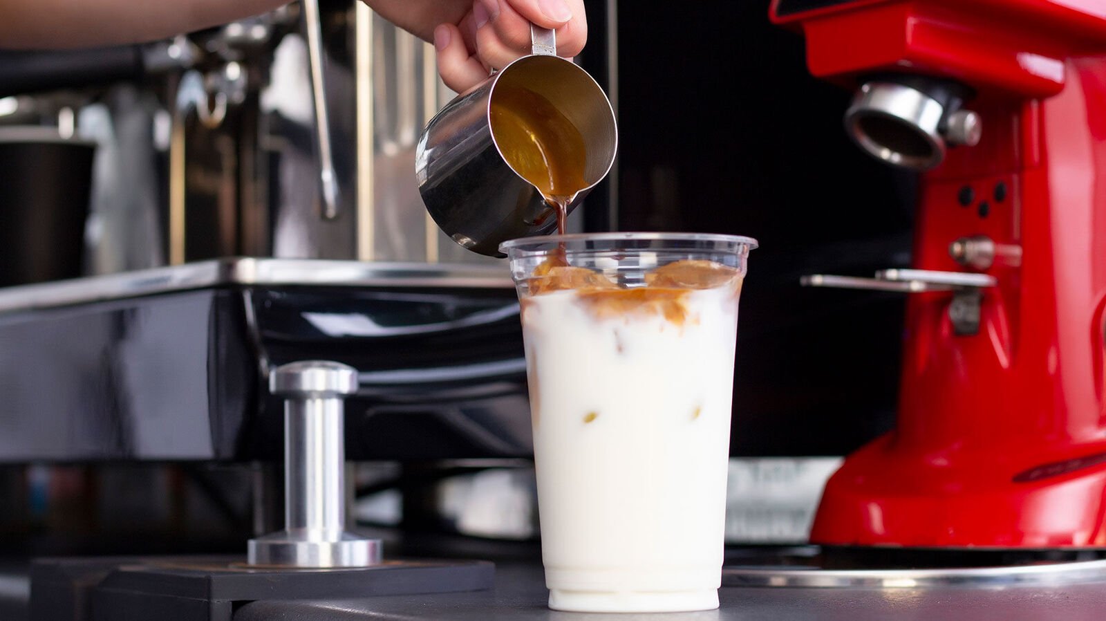 Prohibited: Disposable packaging for drinks for on-site consumption An espresso is poured into a disposable clear plastic cup filled with milk and ice cubes