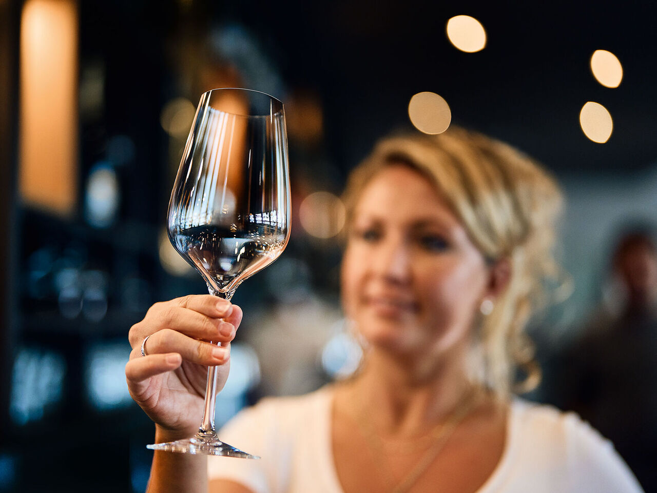 Gläserspülen: Gastronomen lieben brillante Gläser! Kellnerin im Restaurant prüft, ob das gespülte Weinglas makellos sauber ist