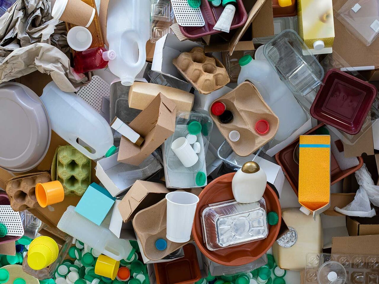 The new Packaging and Packaging Waste Regulation (PPWR) 2025 Various types of recyclable packaging such as plastic bottles, coffee cups, egg cartons, wrapping paper and plastic boxes are piled up on the floor