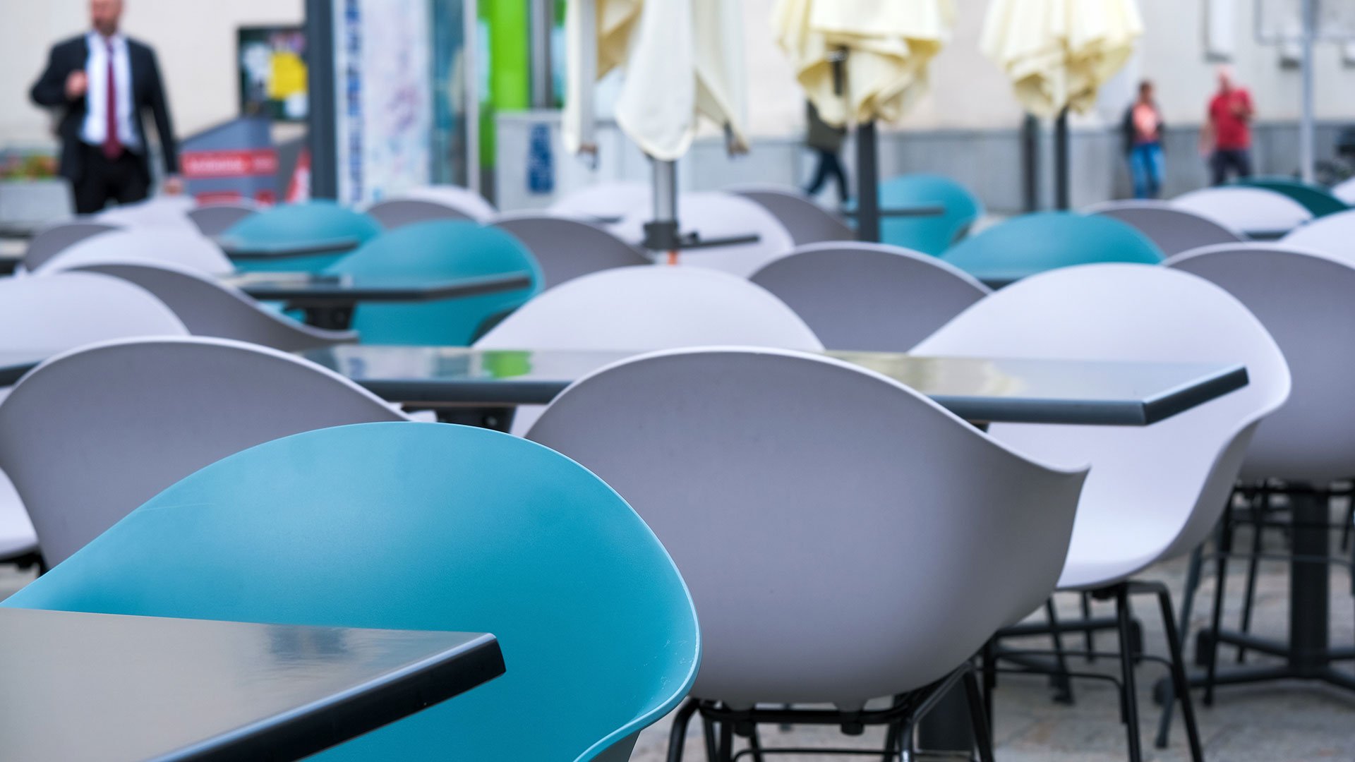 Mistake: Wrong choice of location In the outdoor area of a café, the tables and chairs are empty and the parasols are folded up