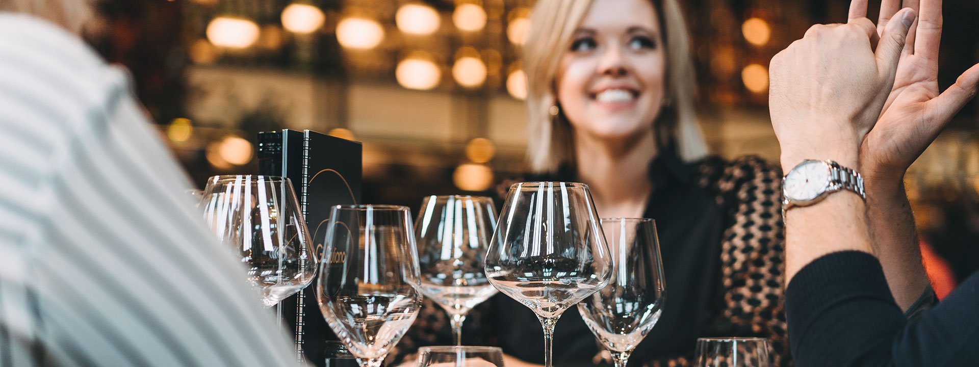 Gäste lieben brillante Gläser! Gäste sitzen in einem Restaurant und haben strahlende Weingläser vor sich auf dem Tisch